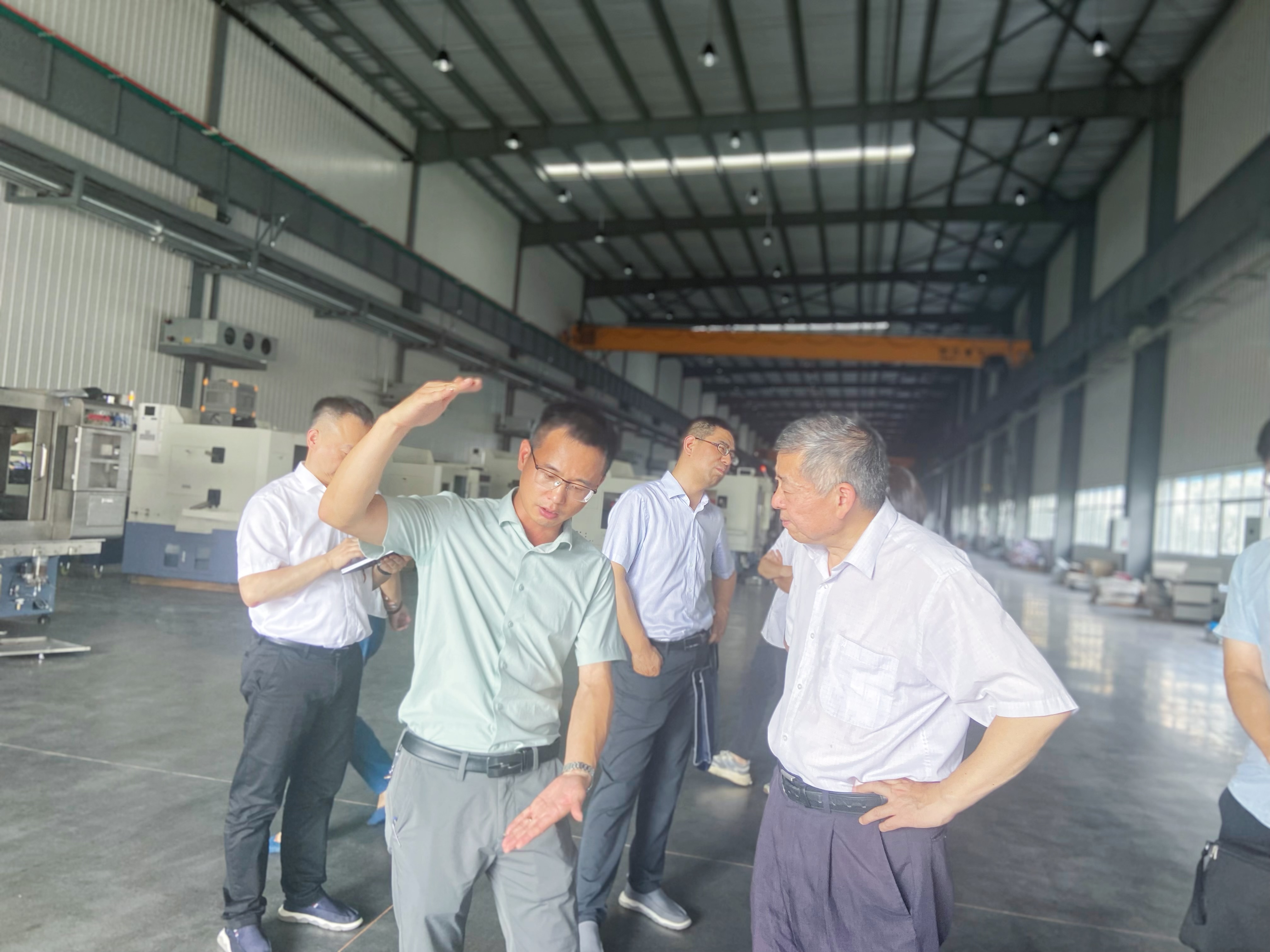 圖為軸承裝備副總經(jīng)理楊新春先生（左）向工信部一級巡視員苗長(cháng)興先生（右）介紹公司設備.JPG